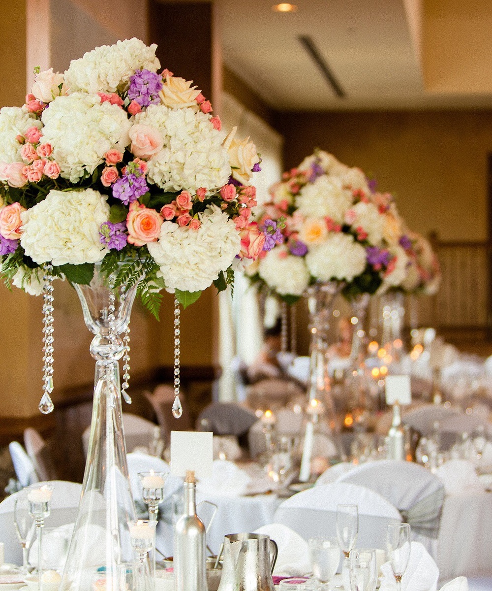 Tall pink and white floral centerpiece on crystal stand for wedding reception